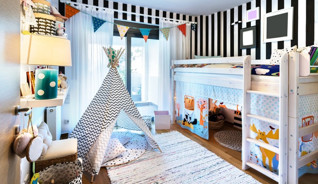 Children’s bedroom with a white bunk bed, striped teepee, and colorful bunting.