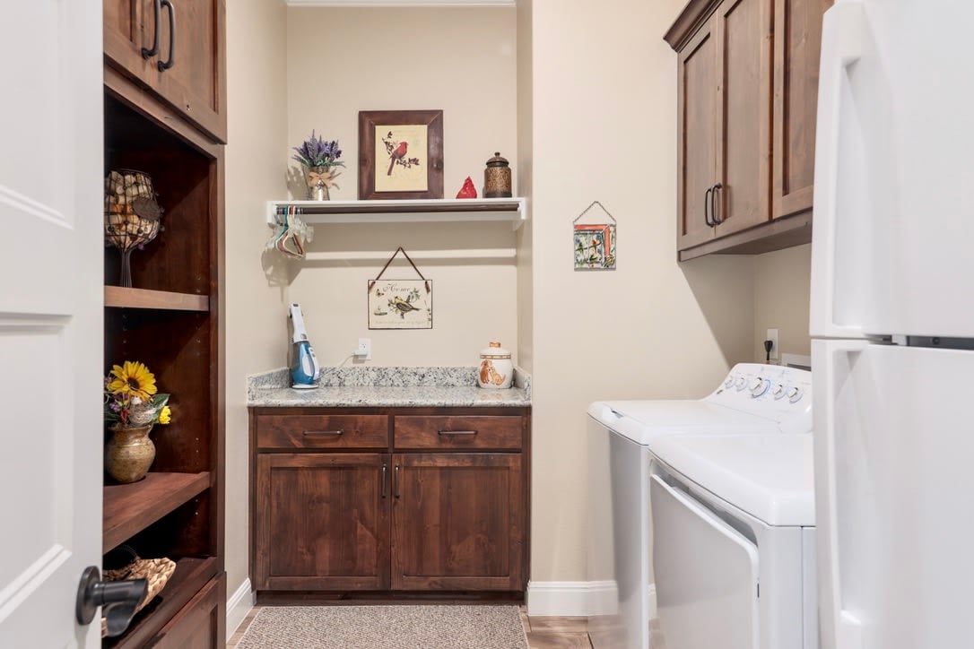 Spacious laundry room with ample cabinetry provides additional storage and organization, enhancing the efficiency and functionality of daily household tasks.