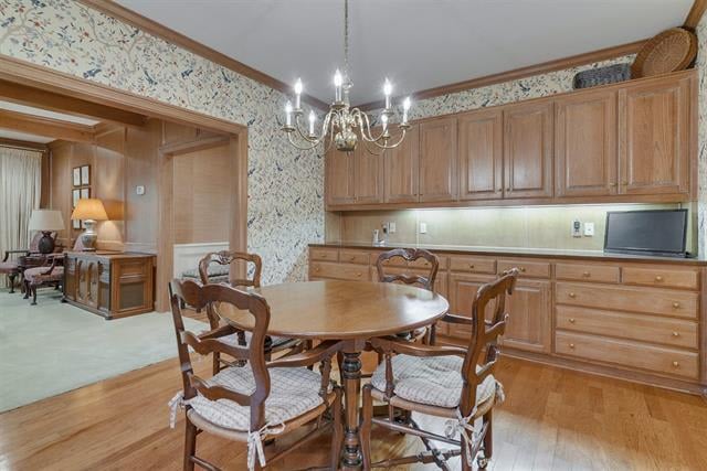 Dining room with a round wooden table, floral wallpaper, and built-in wooden cabinetry.