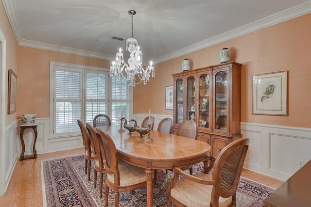Dining room with an oval wooden table, crystal chandelier, glass-front china cabinet and shuttered windows.