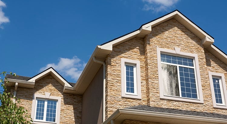 An exterior view of a house with a close-up of its facade. The house has a modern design with large windows and a well-maintained exterior.