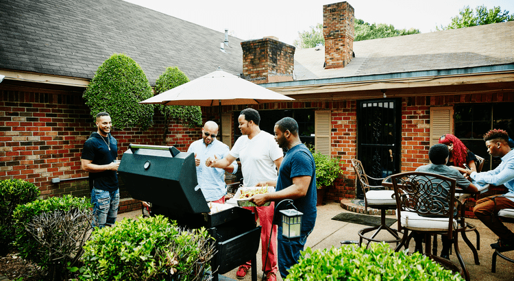 a group of people having a barbecue party in their backyard