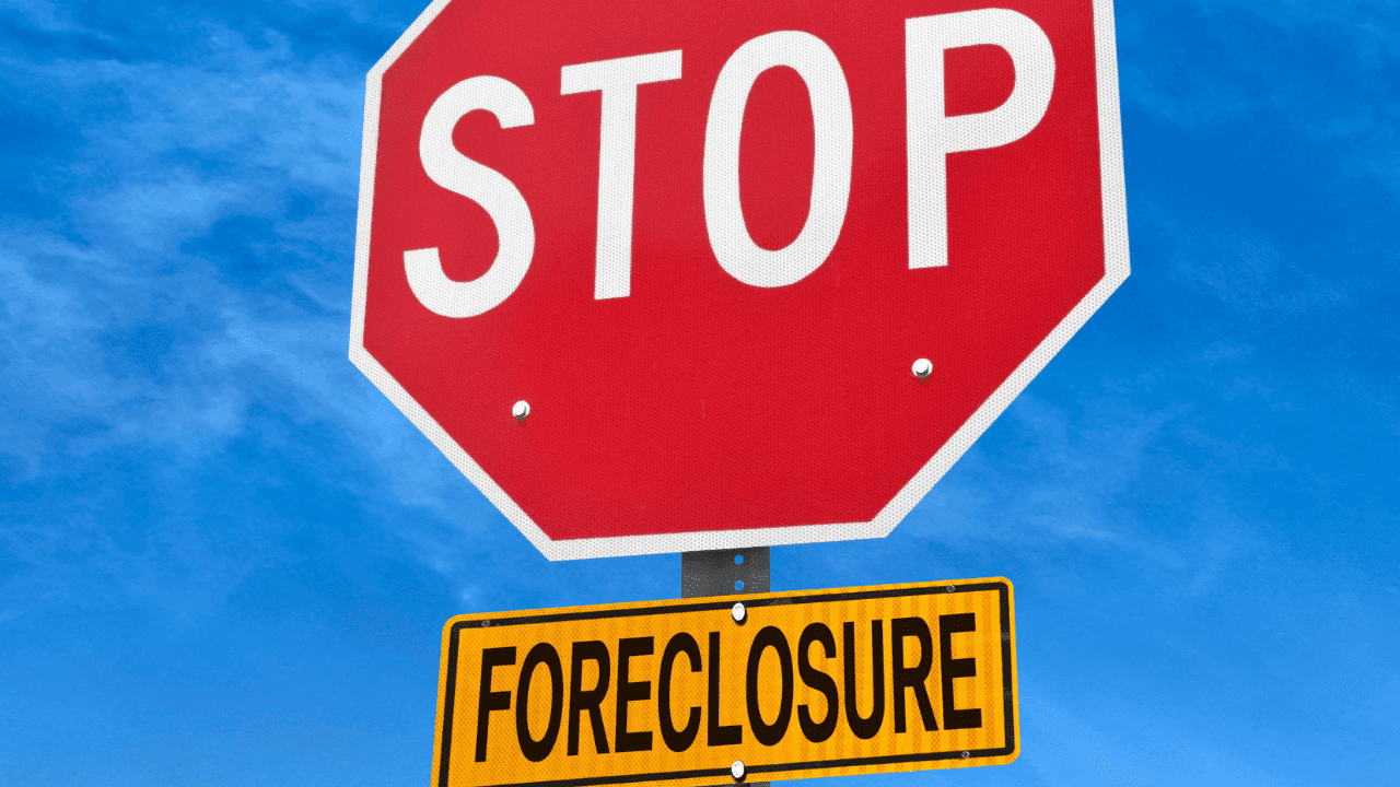 A stop sign with an additional yellow sign underneath it that reads "Foreclosure."