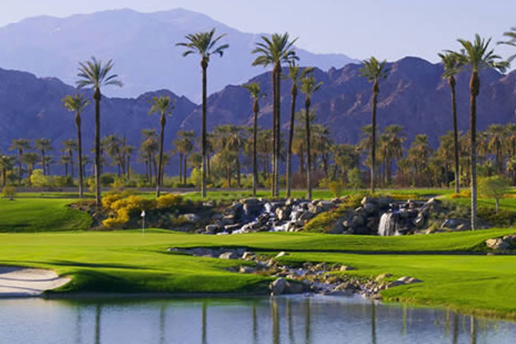 A golf course fairway with a pond and a waterfall in the foreground