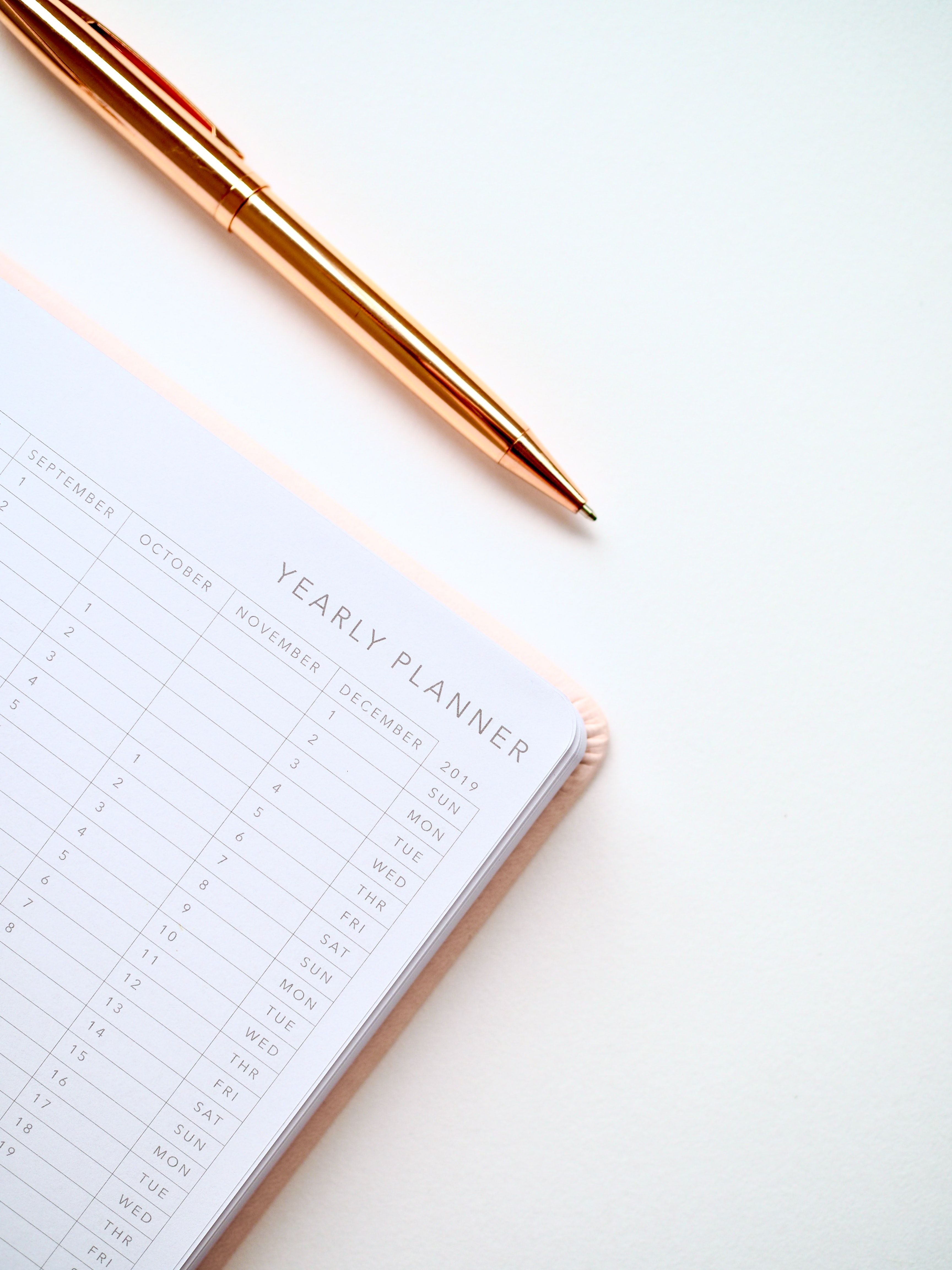 Gold pen above a white yearly planner calendar showing September through December 2019.