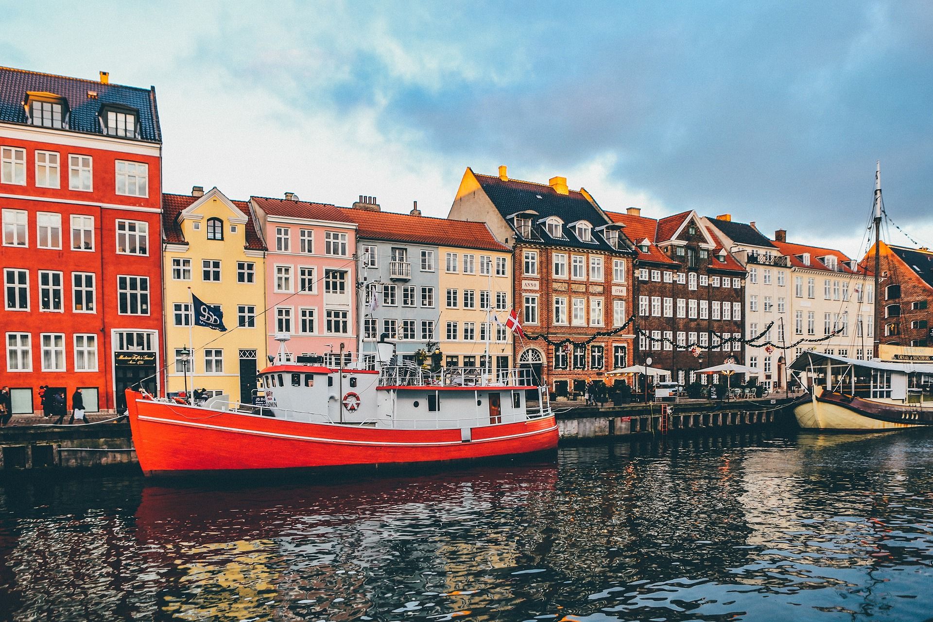 Copenhagen’s Nyhavn canal, with colorful waterfront buildings and a red-and-white boat.