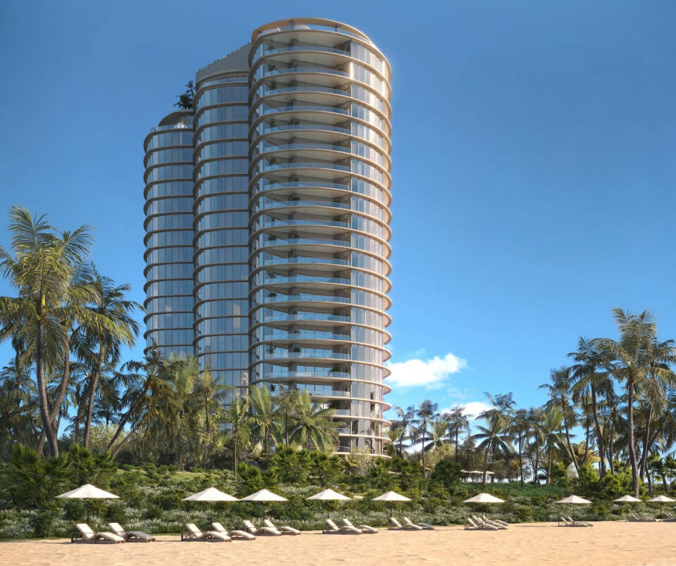 Rivage Bal Harbour's curved glass residential tower rises behind a palm-lined beach.
