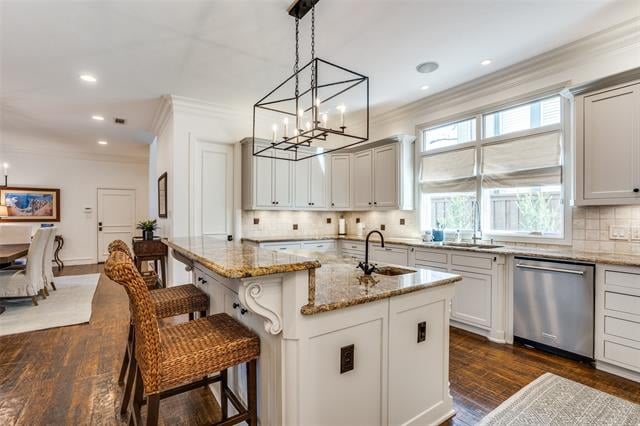 Bright white kitchen with a granite island, woven bar stools, tall windows, and dark wood floors.