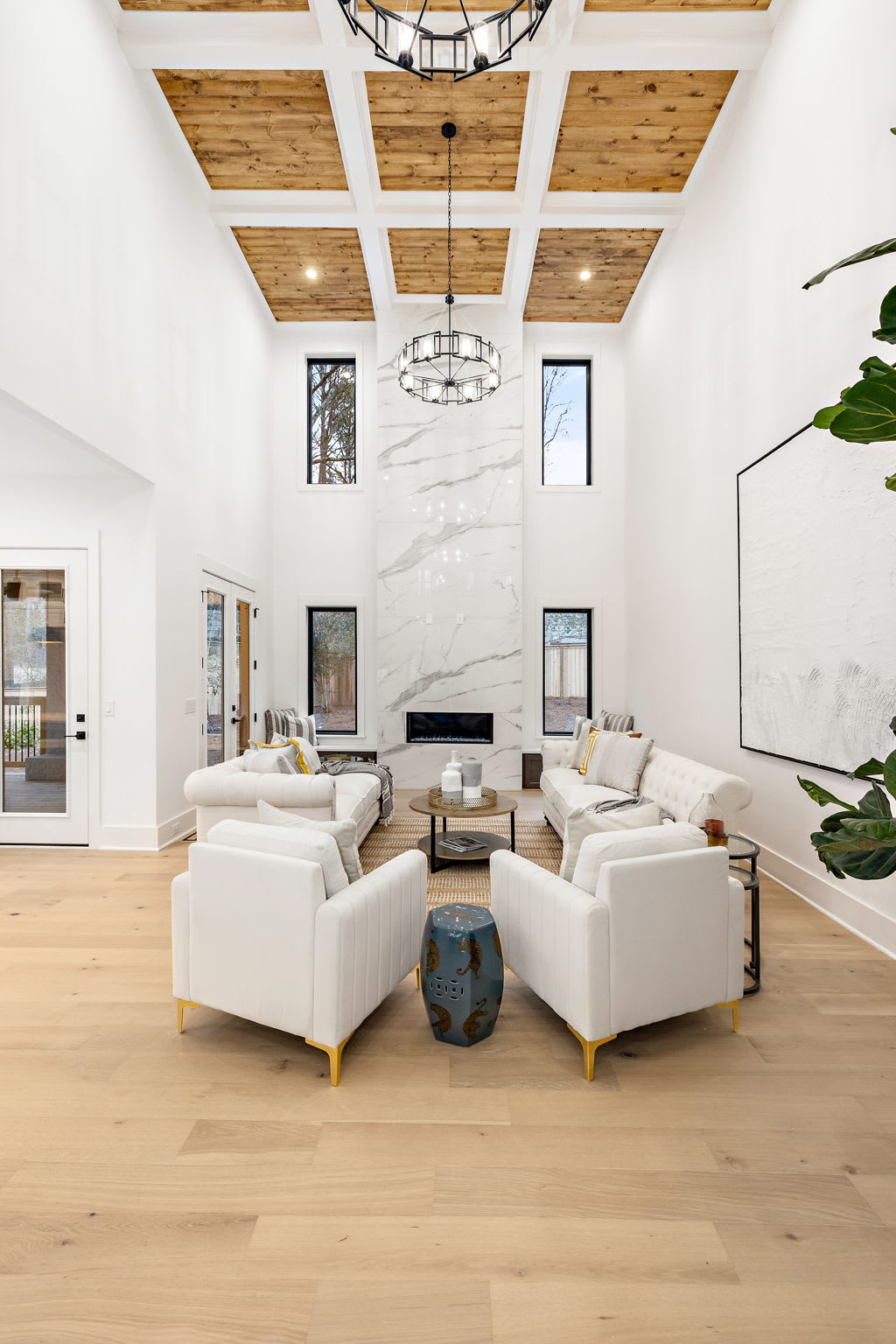 Great room in Ridgewater Bleu luxury home, Marietta GA, featuring a 20 ft fireplace with wood-accented coffered ceiling, offering elegance and charm in sought-after East Cobb real estate near Walton High School.