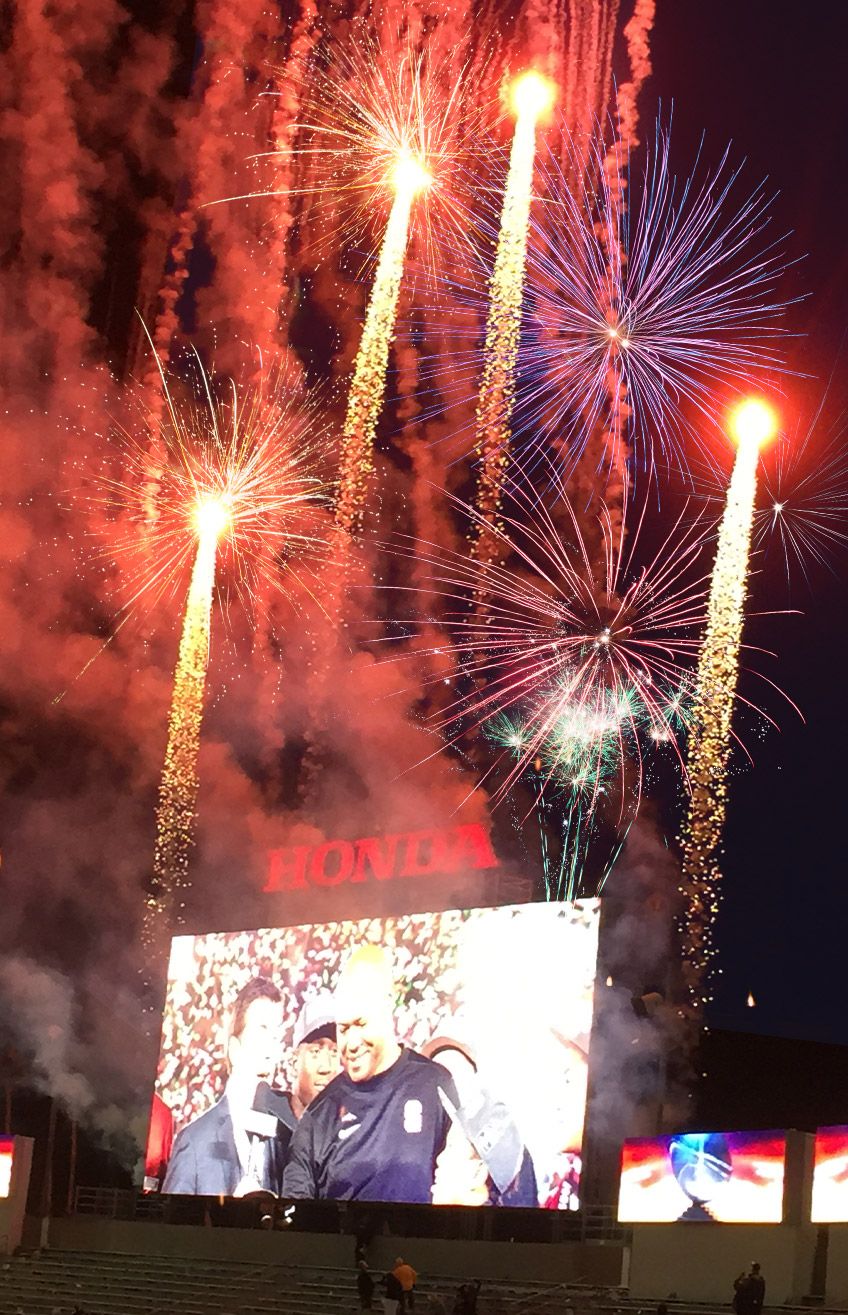 Colorful fireworks burst above a stadium screen displaying HONDA.