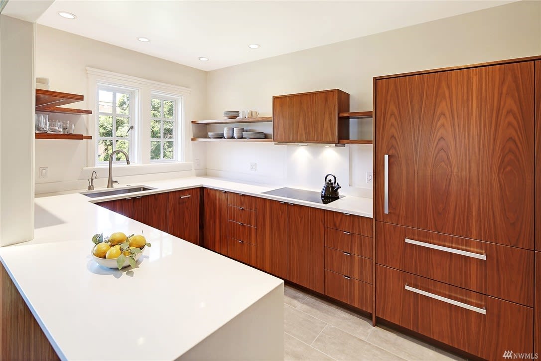 Sleek, modern kitchen with rich wood cabinetry in a high-end home, blending style and functionality.