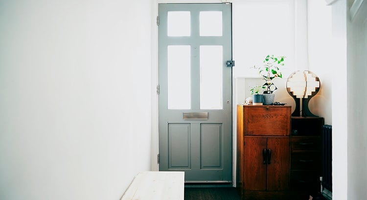 An entrance hallway with a door and a small table with a plant.