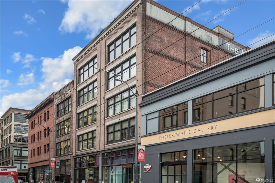 Historic urban building facade with loft apartments above street-level galleries, offering a blend of luxury and culture.