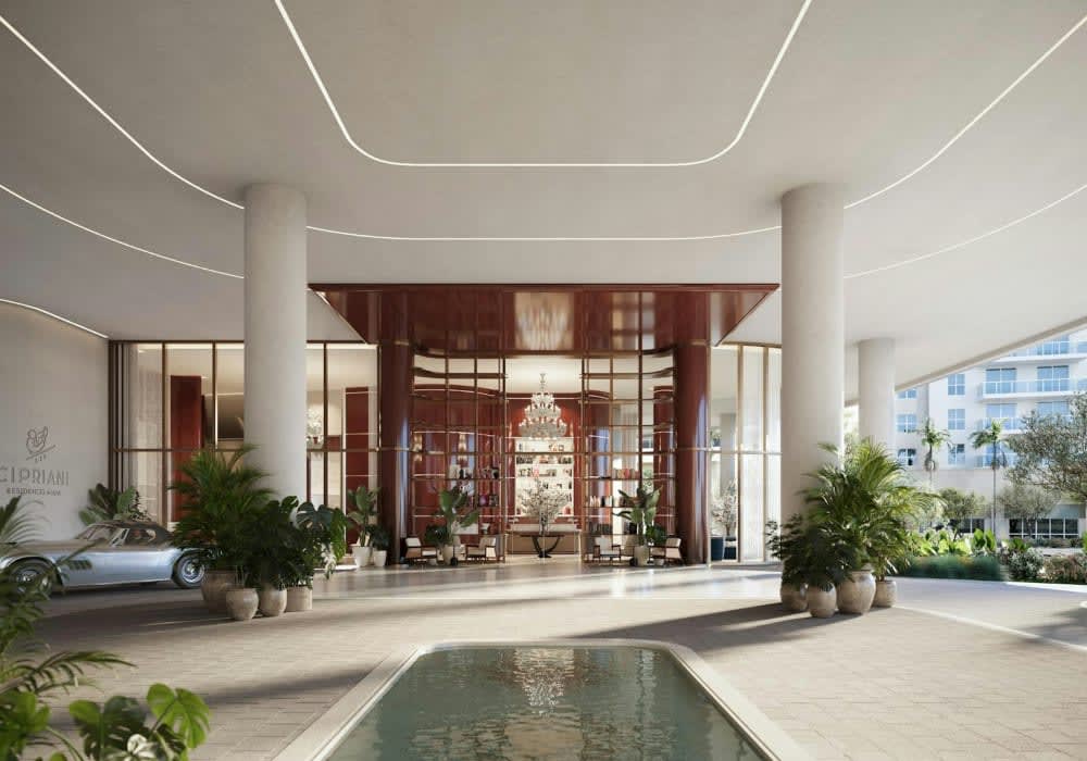 Cipriani Residences lobby with a reflecting pool, palms, and a luxury car.
