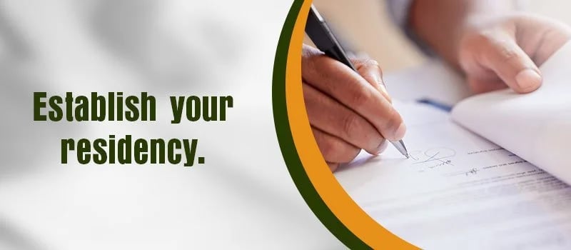 Establish your residency. Hands signing a document.