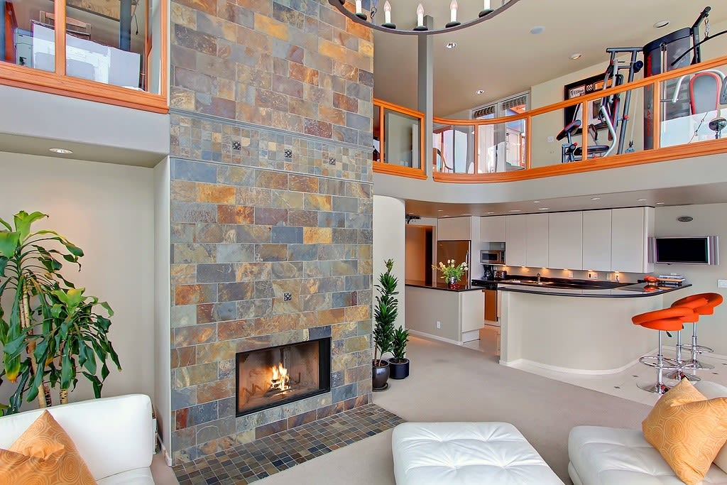 Modern loft-style home with an open-plan kitchen, cozy fireplace, and vibrant accents.