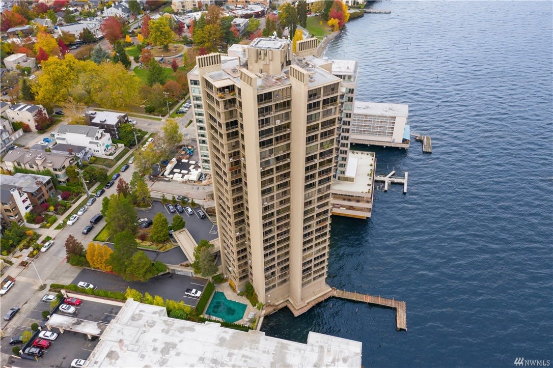 Overhead view of an exclusive waterfront condo high-rise against a backdrop of vibrant fall colors.