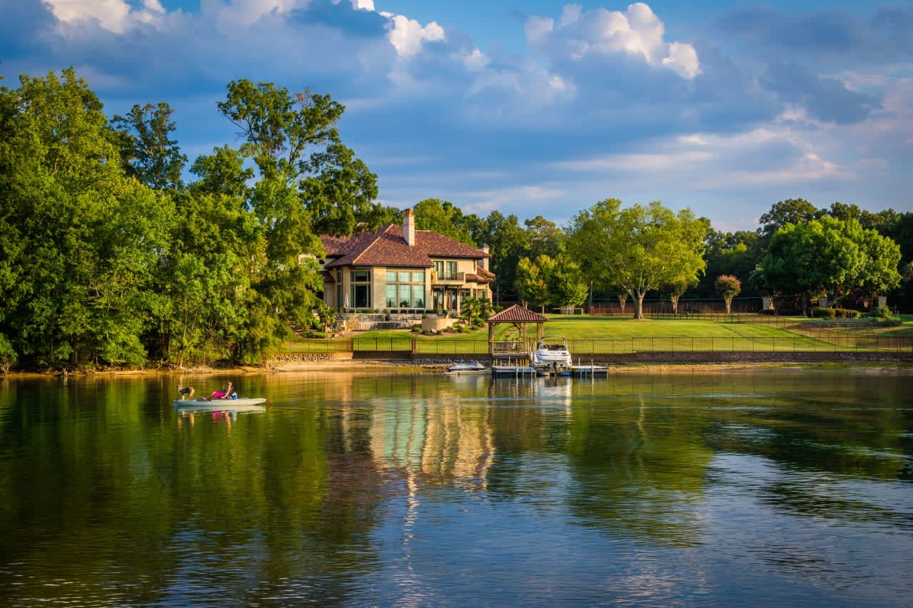 Luxurious lakeside home with lush surroundings reflecting the exclusive and tranquil lifestyle of waterfront living.