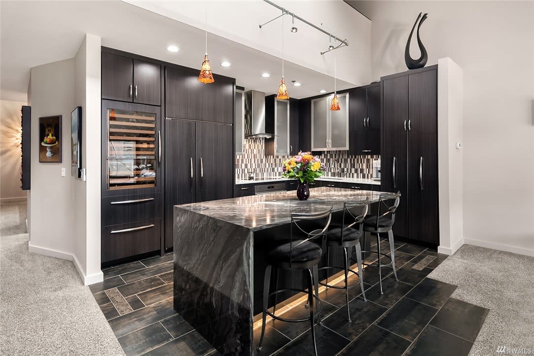 Luxurious kitchen with sleek black cabinets and a stylish bar.