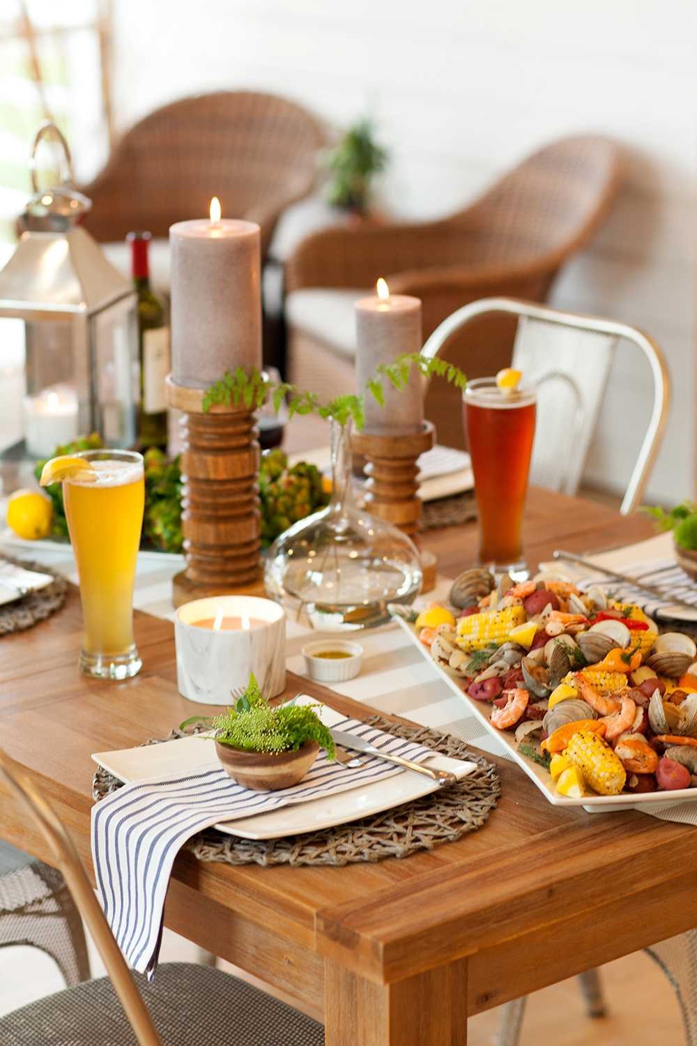 On the table, we placed a subtle striped runner with round wicker placemats and napkins with a classic nautical stripe. Square plates and serving platters gave a modern edge, while the stark white allowed the food to take center stage.