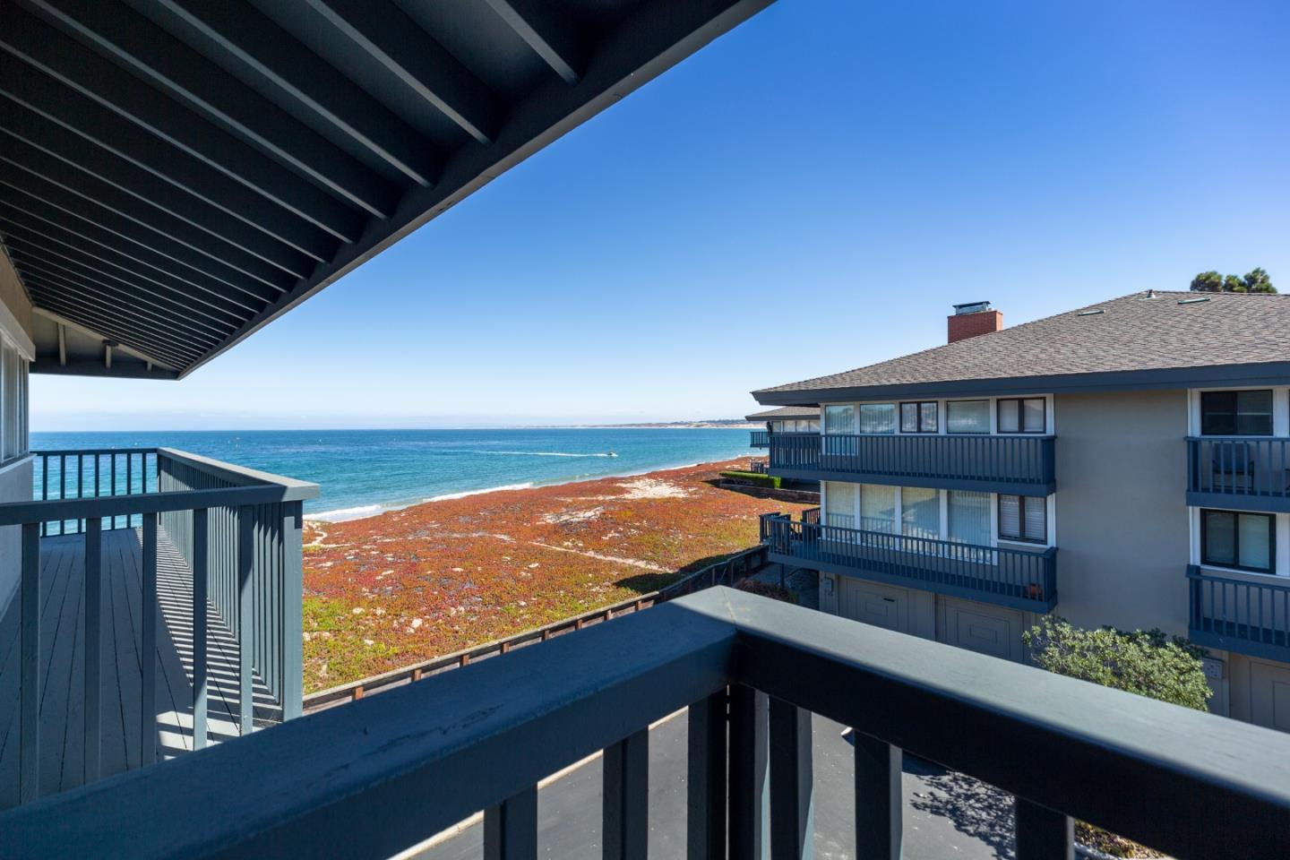 Balcony overlooking the ocean and shoreline, framed by neighboring coastal homes.
