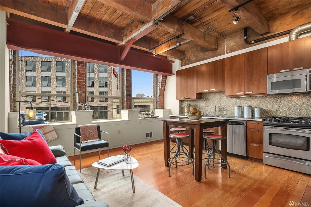 A stylish loft kitchen with a dining table and chairs.