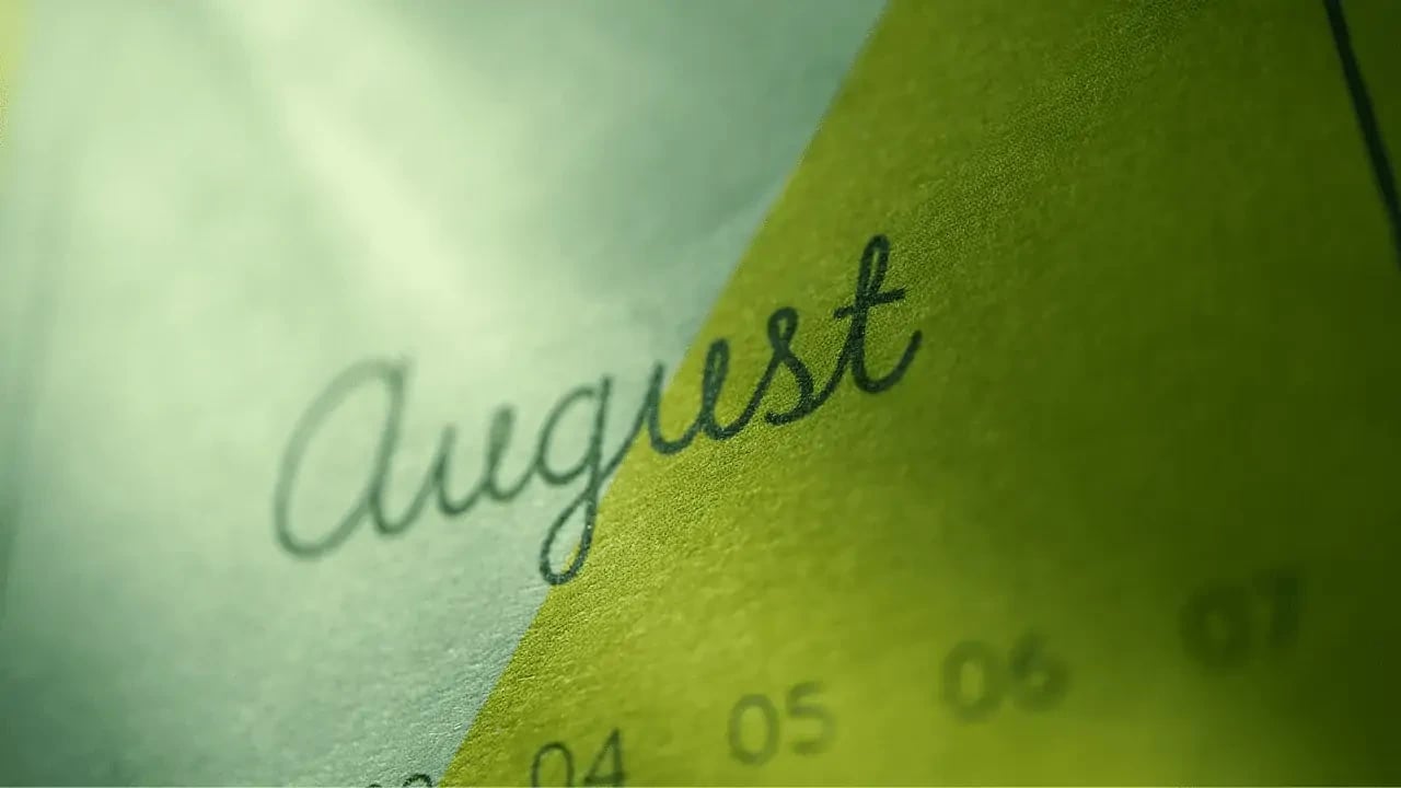  A close-up of a calendar page with the word "August" written in elegant script.