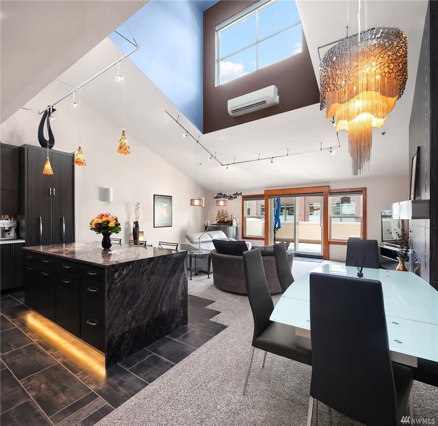 Spacious modern kitchen and living room with skylights in a luxury home.