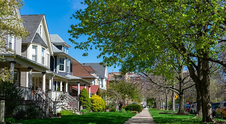 A suburban neighborhood with houses, trees, and a walkway.