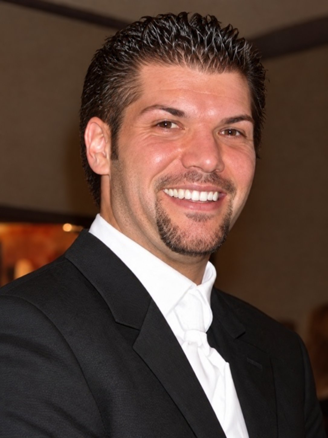 Kevin Overstreet smiling in a black suit jacket and white shirt.