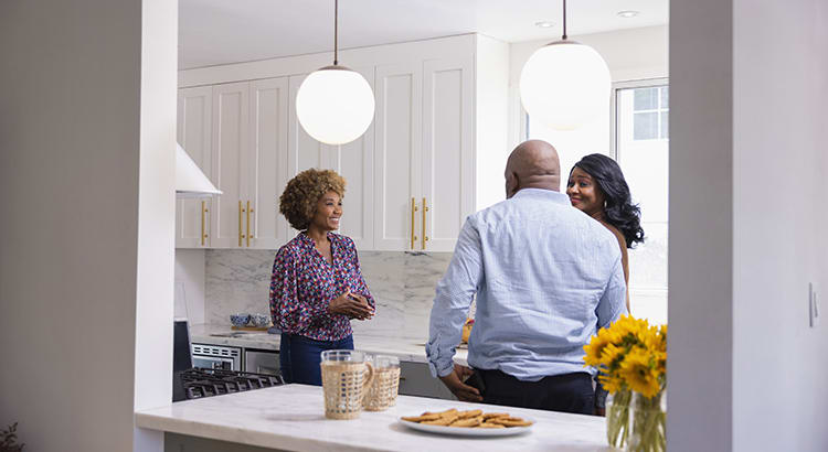 a family in a kitchen, possibly having a conversation or cooking together.