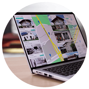 Laptop displaying property listings beside a map.