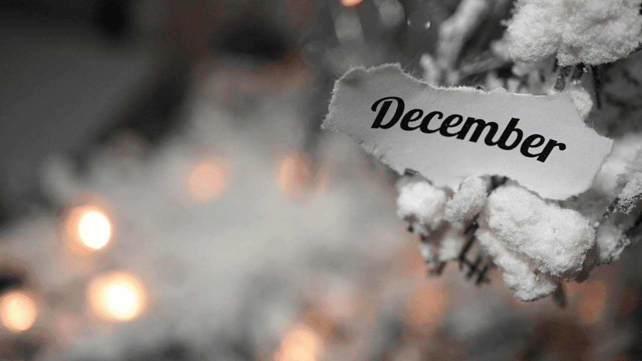 A close-up of a piece of paper with the word "December" written on it in a stylish, bold font. 