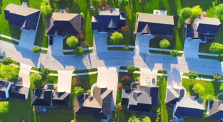  An aerial view of a residential neighborhood with several houses, trees, and streets, possibly illustrating housing density or a specific area.