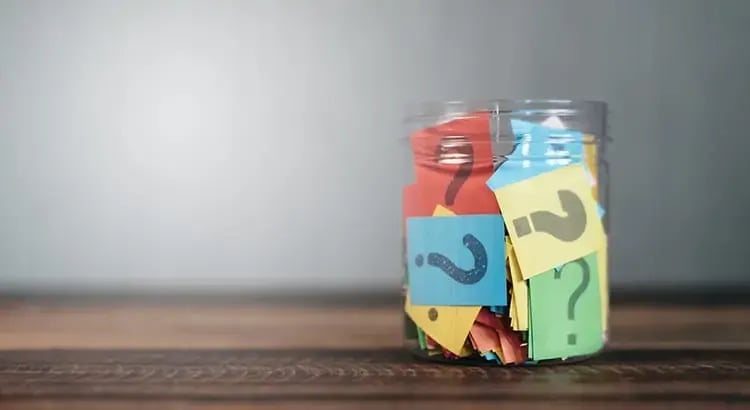 A jar filled with colorful pieces of paper, possibly used for organizing or decoration.