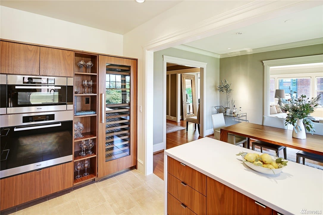 A spacious kitchen with wood finishes and built-in wine storage in a luxury estate radiates sophistication.