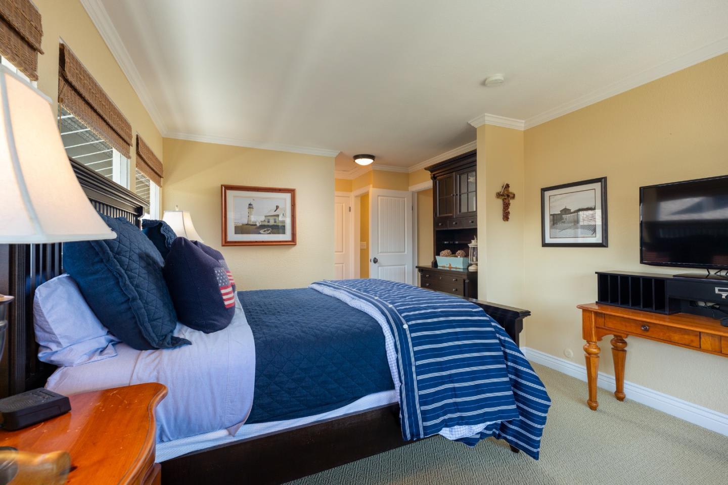 Bedroom with blue-and-white bedding, dark wood furniture, and yellow walls.