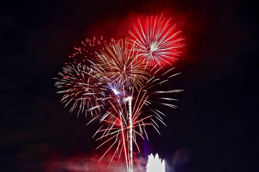 Red, white, and gold fireworks burst against the night sky.