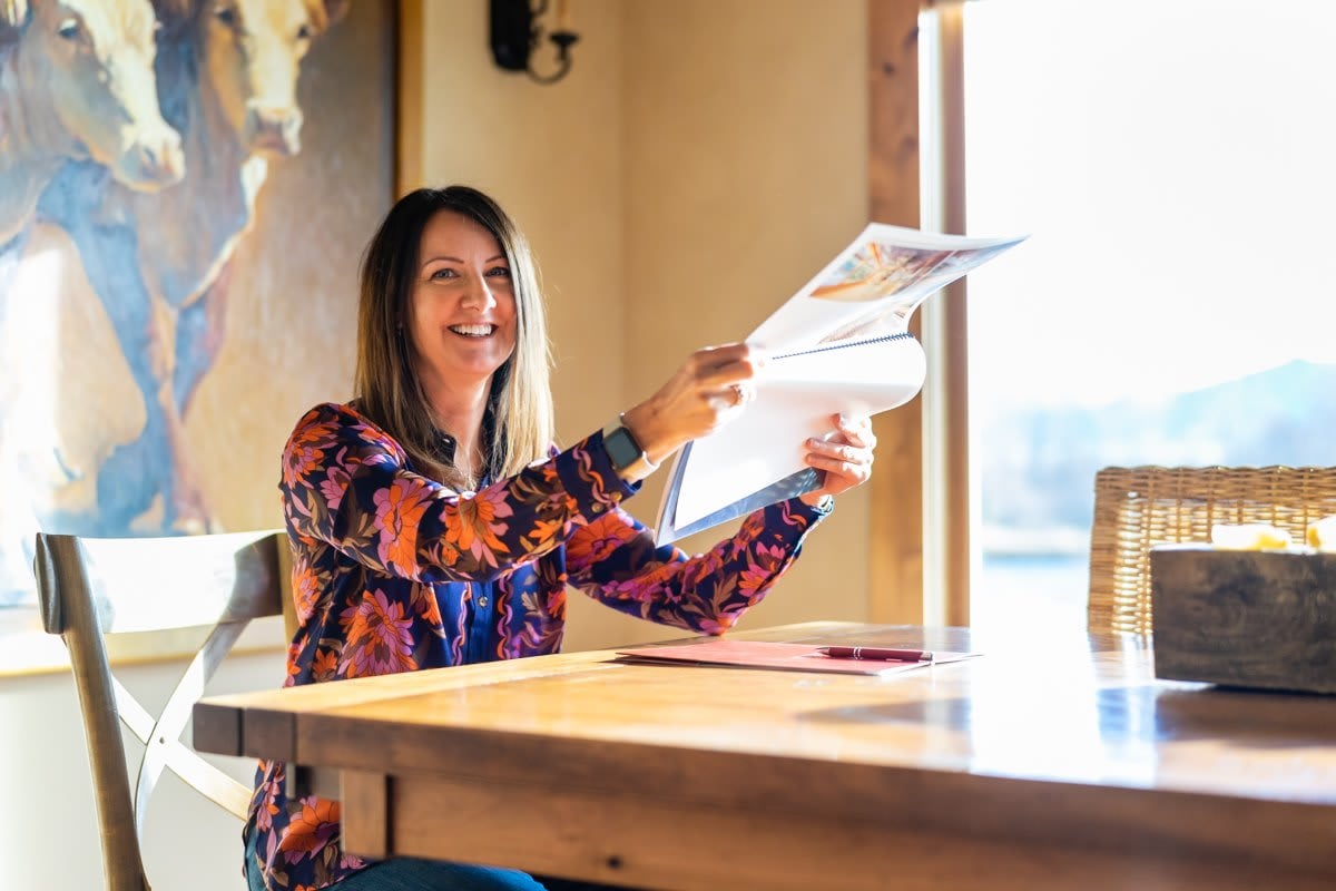 Image of Dawn Myrvik holding up a spiral-bound book