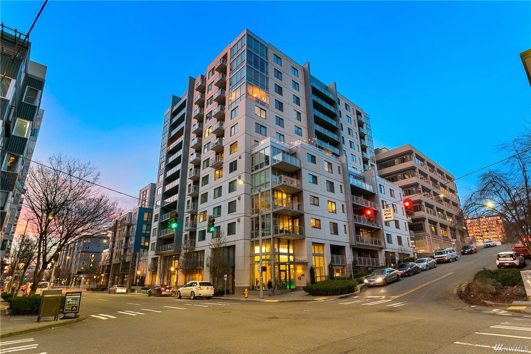 Twilight over a contemporary luxury condo building, capturing the essence of upscale urban living at dusk.