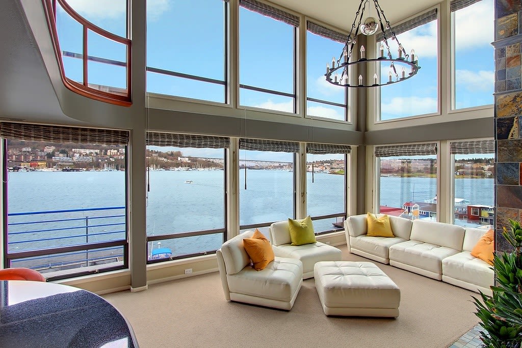 Spacious and bright living room in a luxury condo with large windows offering stunning waterfront views.