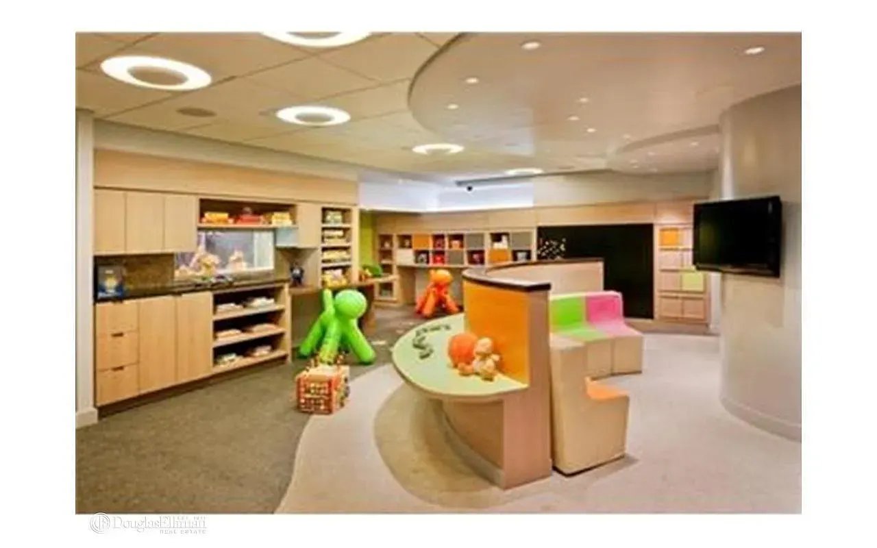 Children’s playroom with built-in storage, colorful seating, toys, and a curved activity counter.