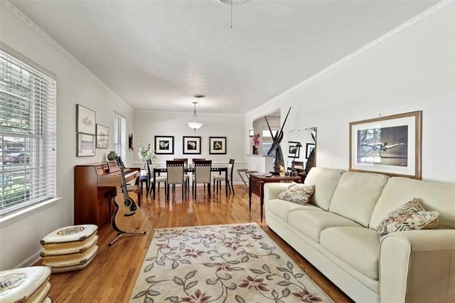 Living and dining room with a cream sofa, patterned rug, and hardwood floors.