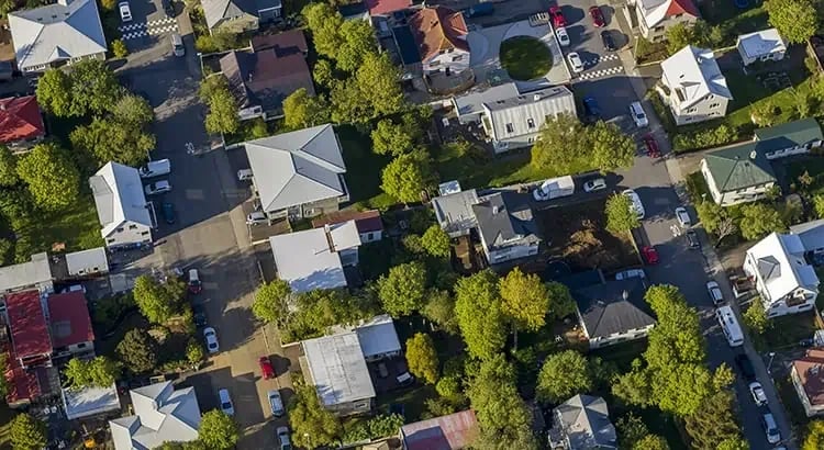 An aerial view of a neighborhood with houses, trees, and streets, showcasing a well-planned residential area.