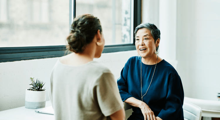 A photograph of two people having a conversation, likely discussing home-related topics. 