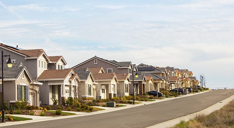 A suburban neighborhood with houses lined up along a street.