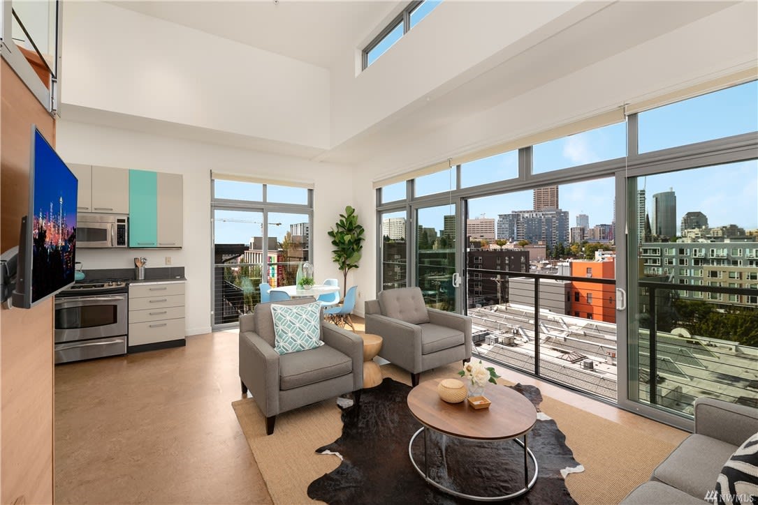 Bright, high-ceiling condo with a modern kitchen and floor-to-ceiling windows.