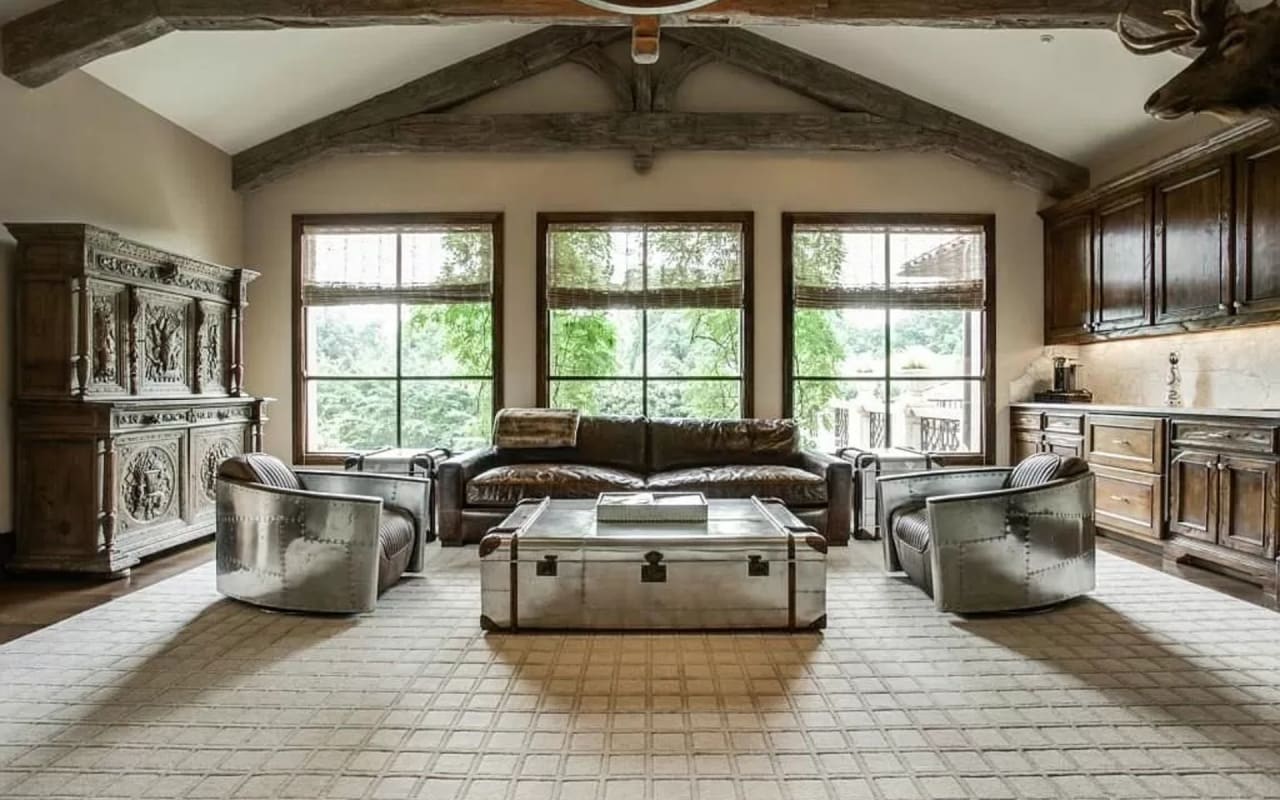 Charming and sophisticated upstairs living room, showcasing a rustic farmhouse style with striking wooden beams.