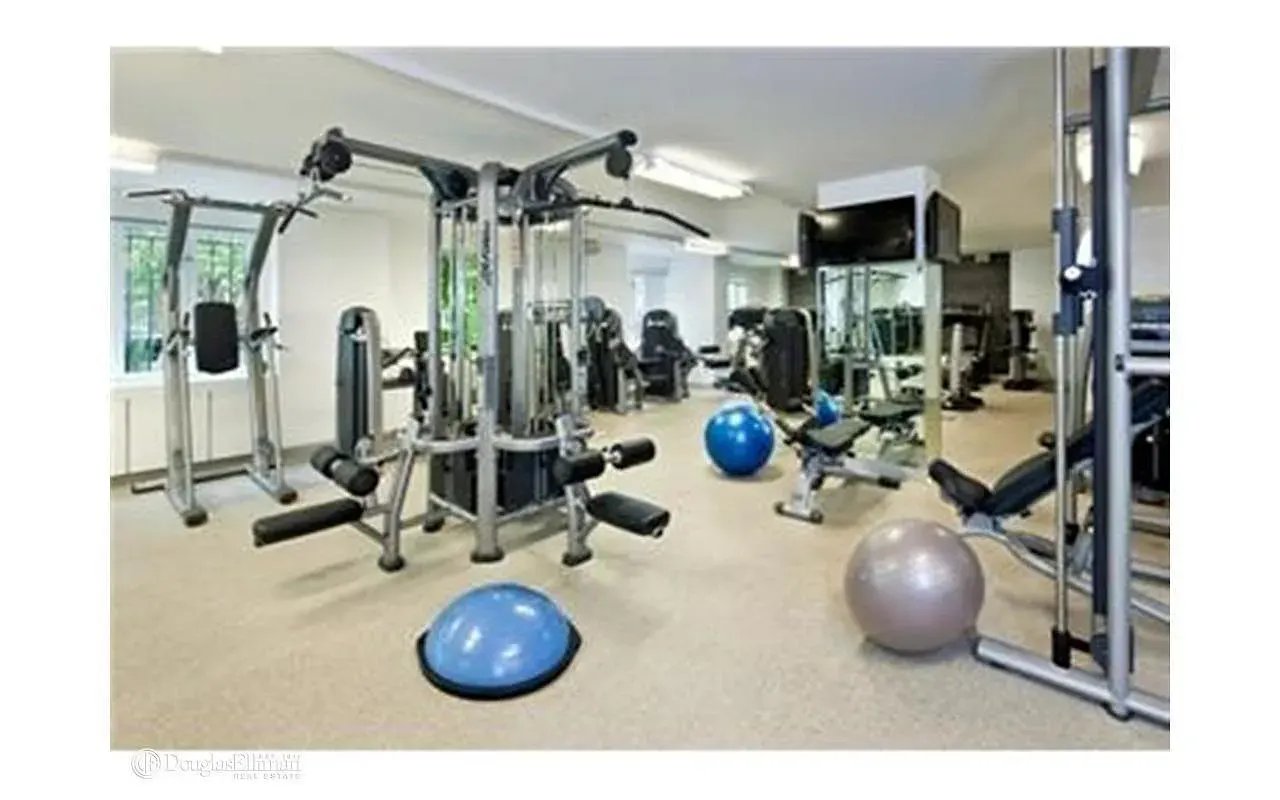 Building fitness center with weight machines, benches, mirrors, and exercise balls.