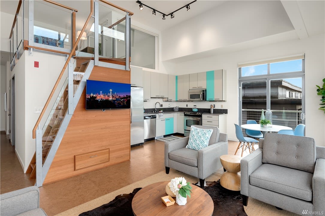 Chic loft condo with modern kitchen, open living space, and abundant natural light, perfect for urban living.